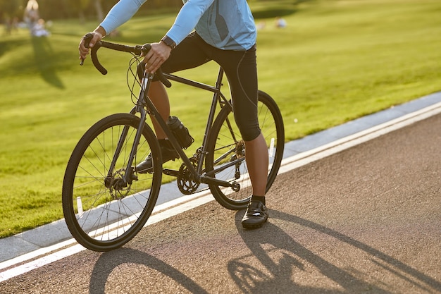 Fietsen bij zonsondergang bijgesneden opname van een man in sportkleding die staat met zijn fiets aan