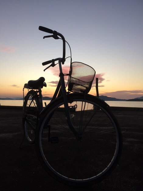 Foto fietsen over zee tegen de hemel tijdens de zonsondergang