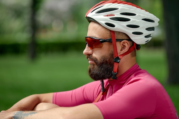 Fietser die rust neemt in het groene gras Zomertijd geweldig humeur