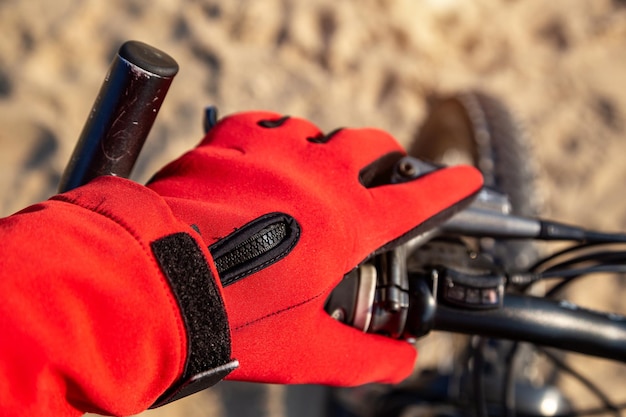 Fietser houdt het stuur in handschoenen rust op het strand in de zomer