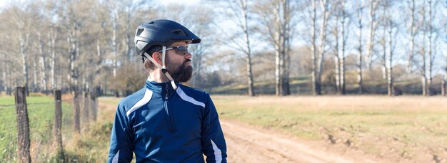 Fietser in broek en fleecejack op een moderne carbon hardtail-fiets met een luchtgeveerde vork rijdt offroad