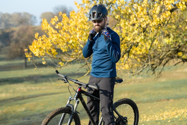 Fietser in broek en fleecejack op een moderne carbon hardtail fiets met luchtgeveerde voorvork