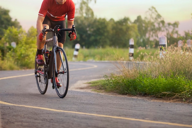 Foto fietser in een weg in openlucht in zonsondergangtijd