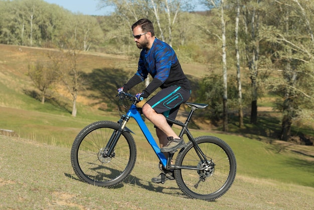 Fietser in korte broek en jersey op een moderne carbon hardtail fiets met luchtgeveerde voorvork