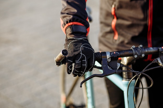 Fietser in zwarte kleding en helm traint op een fiets