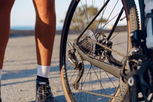 Fietser man voeten en fietswiel kustweg