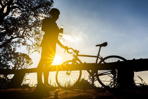 fietser met een fiets silhouet op zonsondergang hemelachtergrond