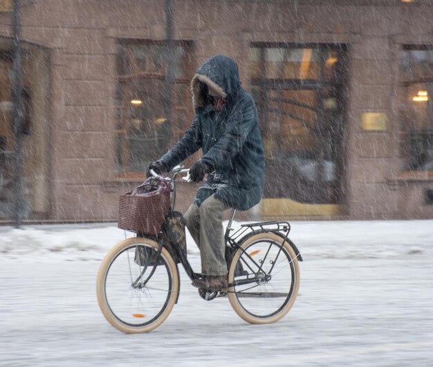 Fietser op de weg van de stad in een besneeuwde dag in bewegingsonscherpte. onscherpe afbeelding