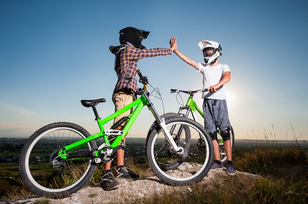 Fietsers met mountainbikes op de heuvel onder de blauwe hemel