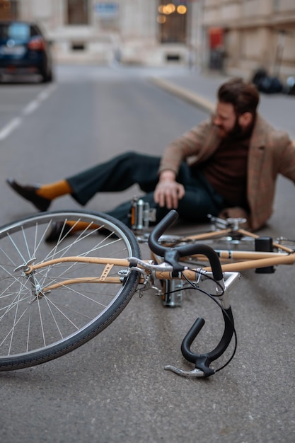 Fietsongeval in de stad Man fietser viel van de racefiets tijdens het fietsen Fietsblessure gewonde knie