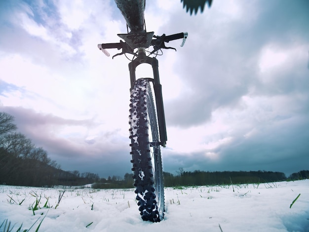 Foto fietswiel in de sneeuw gedetailleerd extreme close-up lage hoek zicht sneeuwig gefileerd in open landschap