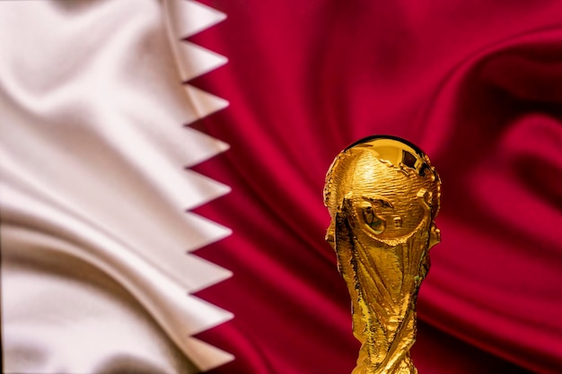 Foto fifa wereldbeker trofee op de achtergrond van de qatar vlag