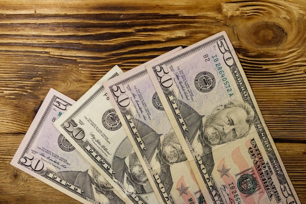 Closeup Of Fifty Dollar Bills On Wooden Table. Fifty Dollar Stock