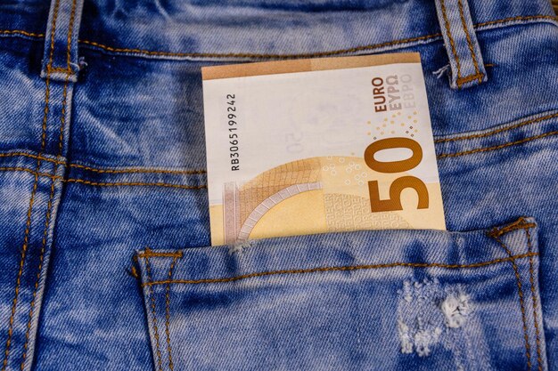 Banconota da cinquanta euro nella tasca dei jeans blu