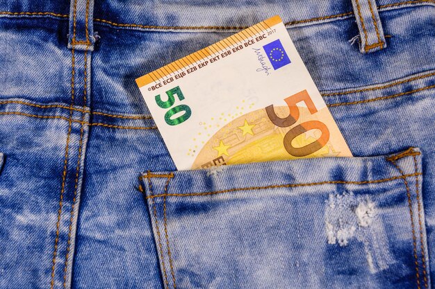 Fifty euro banknote in pocket of the blue jeans