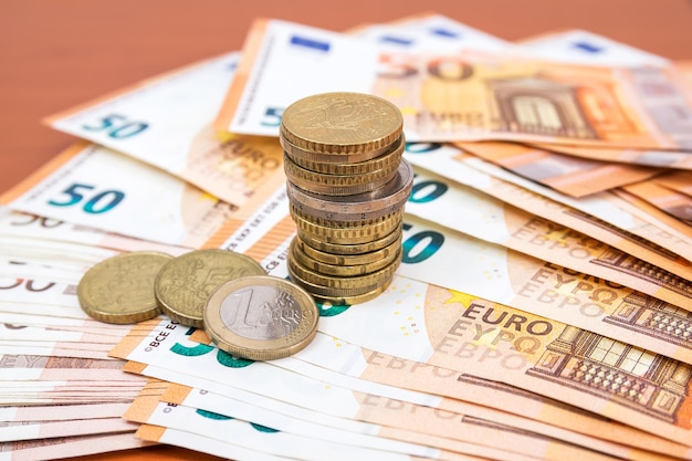 Cinquanta banconote e monete in euro. concetto finanziario.