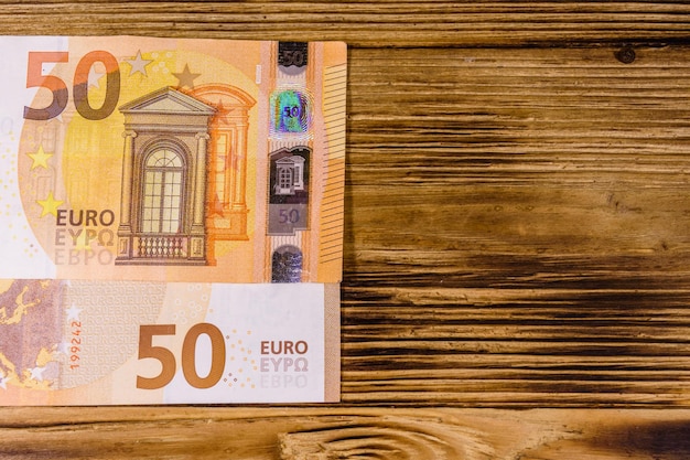 Fifty euro banknotes on rustic wooden background. Top view