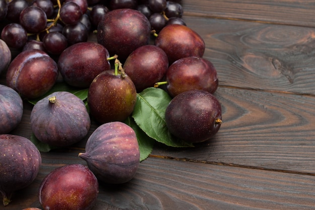 Fig fruits and plums on wooden board