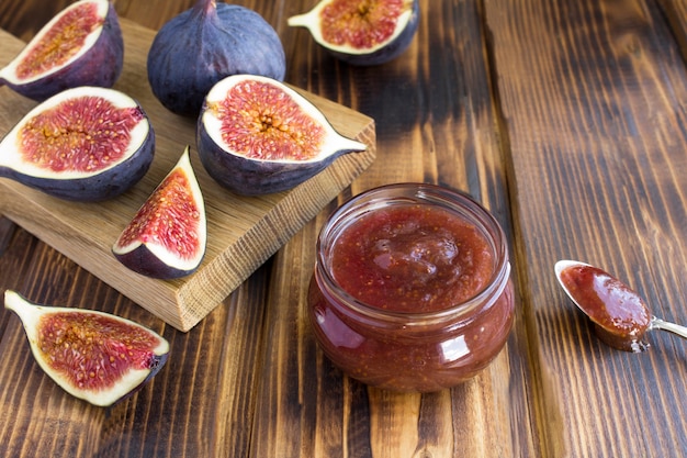 Photo fig jam in the glass jar on the brown wooden table