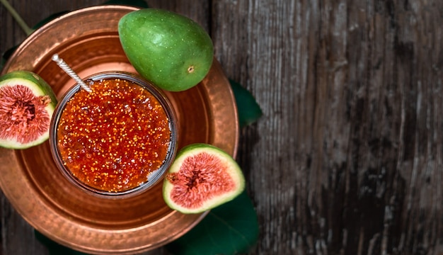 Fig jam in a glass jar on a copper Turkish dish