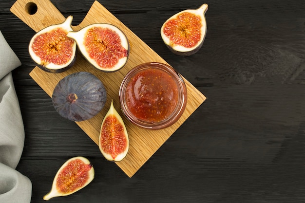 Fig jam in de glazen pot op een houten bord