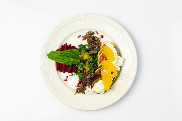 Fig salade met geitenkaas en bieten, op een witte plaat, bovenaanzicht