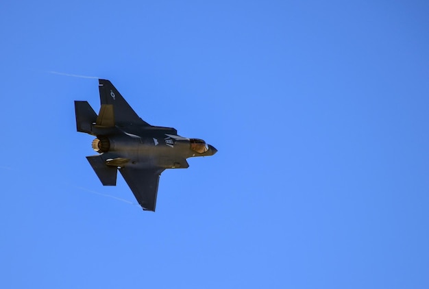 A fighter jet is flying in the sky with the words f - 35 on the tail