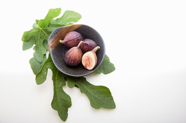 Figs in a a bowl with fig leaf