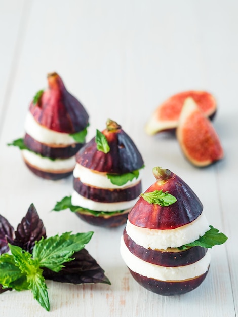 Figs and cheese appetiezer with basil and mint leaves