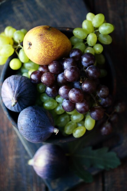 Figs and grapes in a wooden bowl, rustic still life