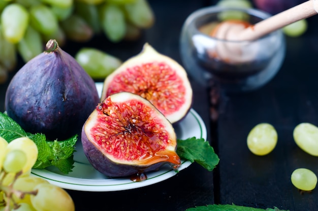 figs and honey on wooden table background.