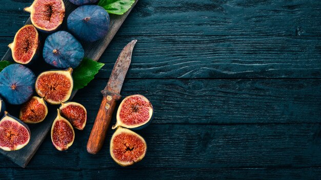 Figs on a wooden board Slice figs On a dark background Free space for text Top view