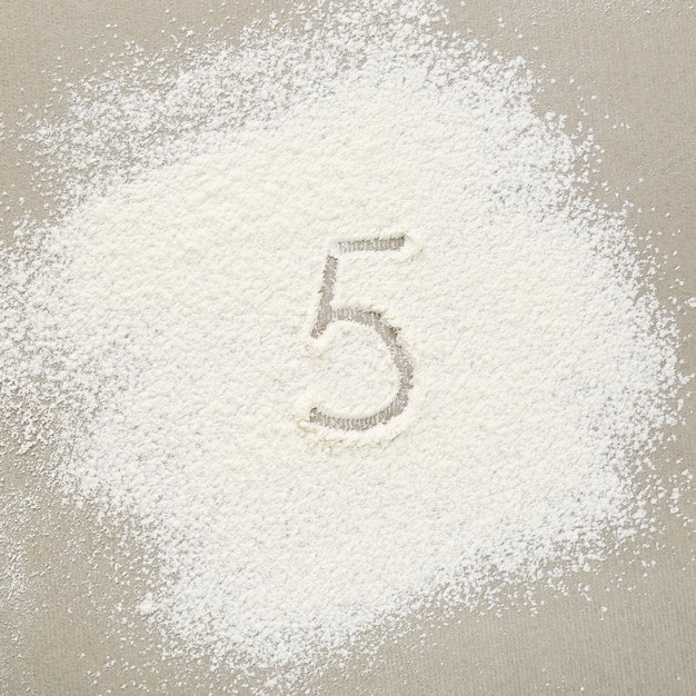 Figure FIVE written on flour