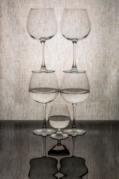 A figure from different glasses with liquid with reflection