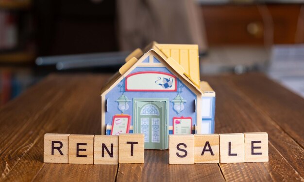 Photo figure of a house together with the words rent and sale concept of rental housing real estate