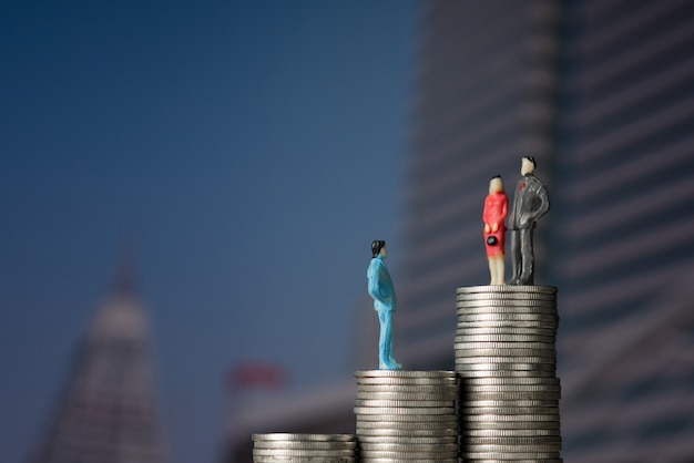 Figure miniature businessman standing on stack of coin