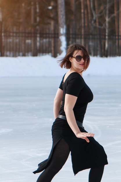 Figure skater on ice. the girl is skating. ice under the open\
sky. no makeup in winter, red cheeks