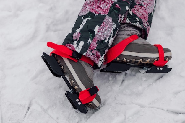 Figure skating skates closeup of child legs and children ice skates worn on them snow background