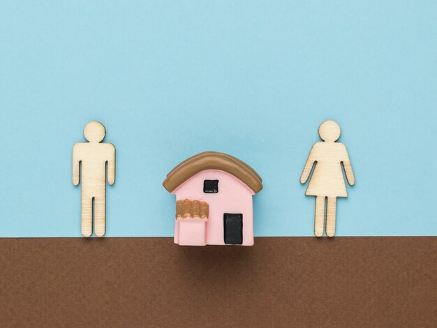 A figure of a small apartment house and a man and a woman standing next to each other.