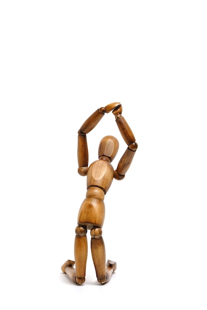 Photo figure wooden mannequin kneeling with his hands raised up