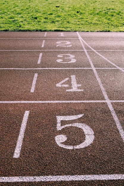 Figuren op een rubberen loopband op een sportveld buiten.