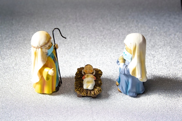 Figuren van Sint-Jozef, de Maagd Maria en het pasgeboren kindje Jezus met hygiënische maskers.