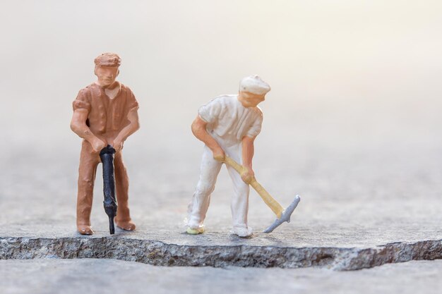 Figures construction worker is working on a cracked area