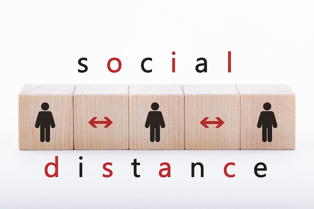 figures of people on wooden blocks depicted in the distance the concept of social distance