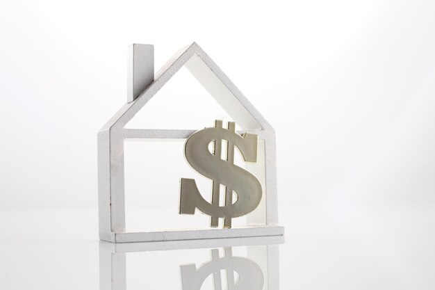 Photo figurine house and dollar sign against white background