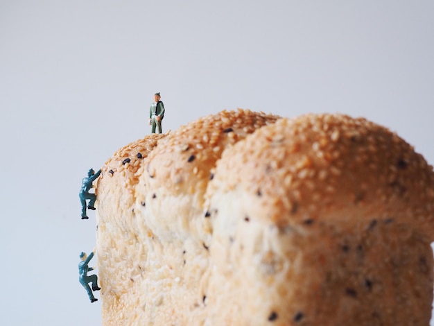 Figurine men on bread over white background