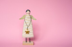 figurine of an angel with a star on a pink background