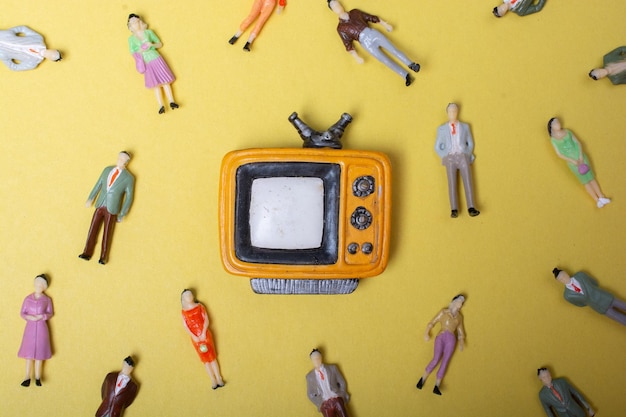 Figurine people around retro syled tiny television