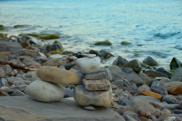 日没の黒海ロシアの海岸の大きな石に小さな石の置物
