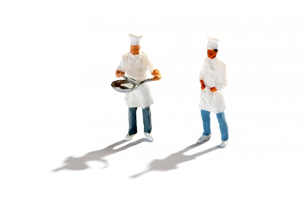 Figurines of chefs against white background